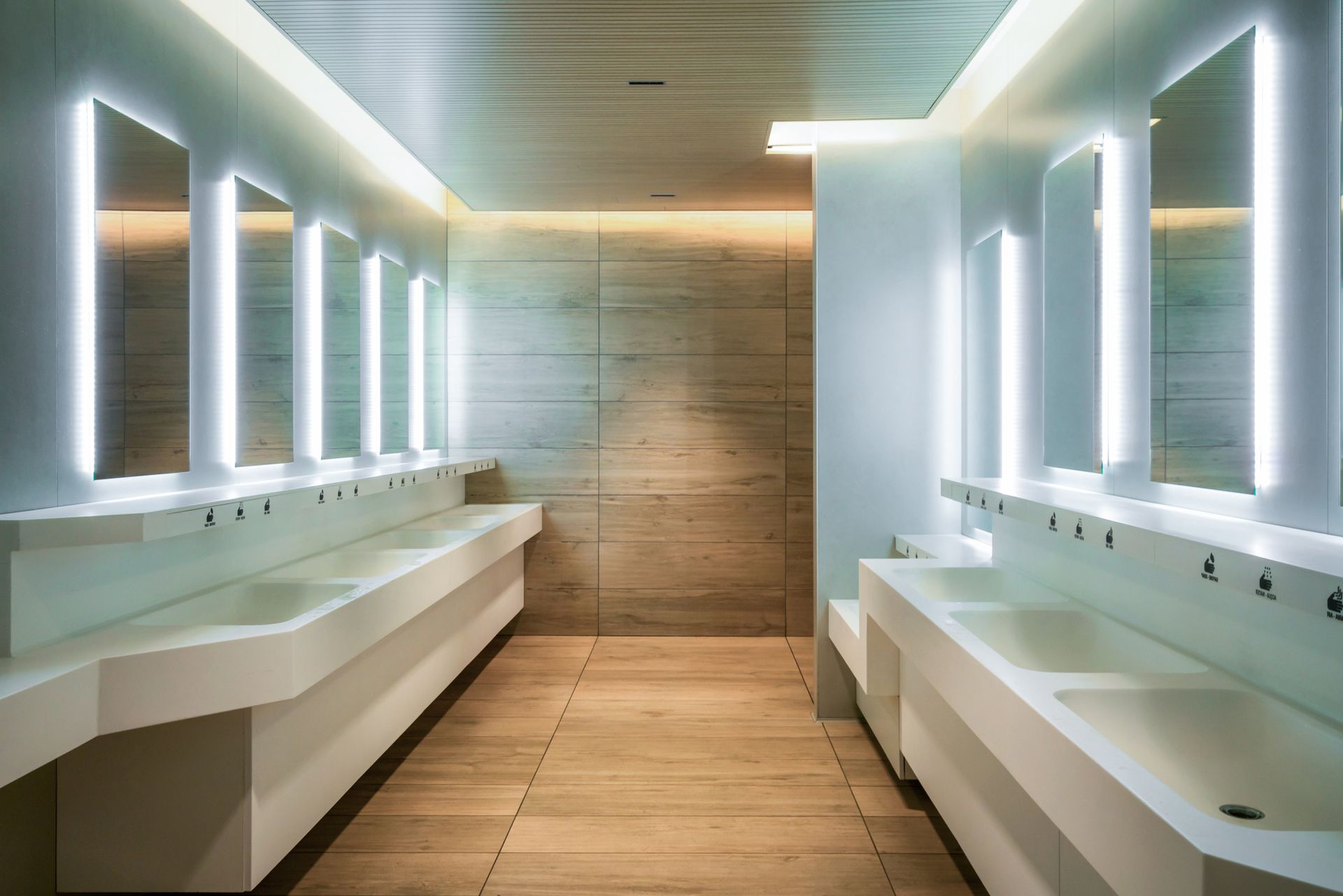 a public restroom with a lot of sinks and mirrors .