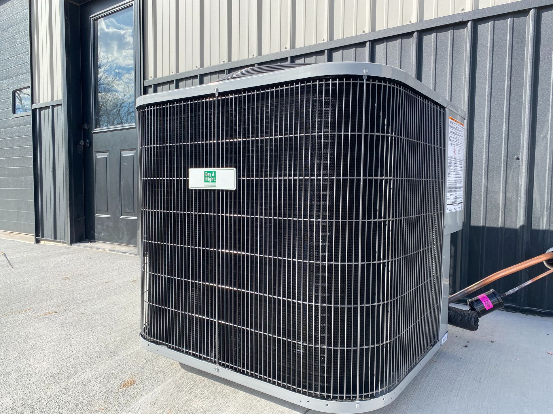 two air conditioners are sitting on the side of a brick building .