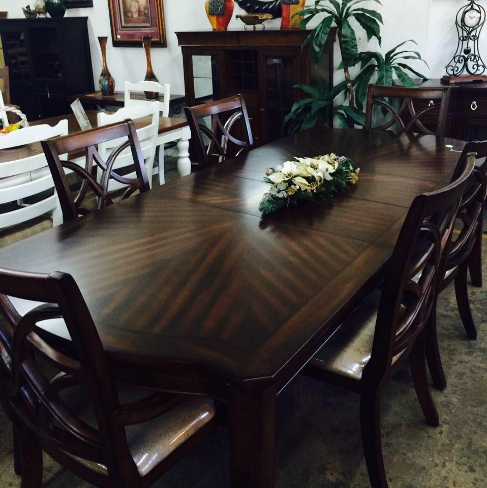 A dining room table with a vase of flowers on it