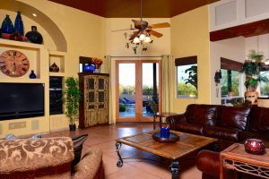 A living room with a ceiling fan and a clock on the wall