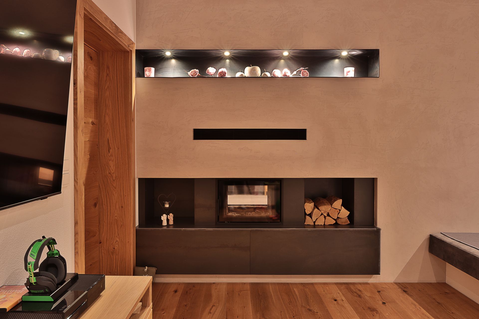 Modernes Wohnzimmer mit beiger Wand, eingebautem Kamin, Holzboden und eingelassenen Regalen