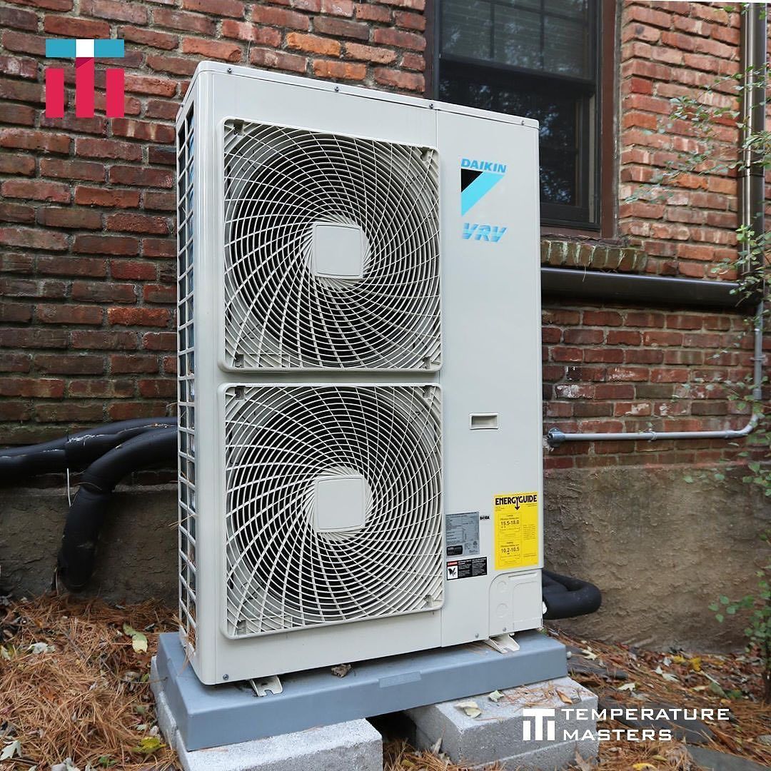 A daikin air conditioner is sitting outside of a brick building