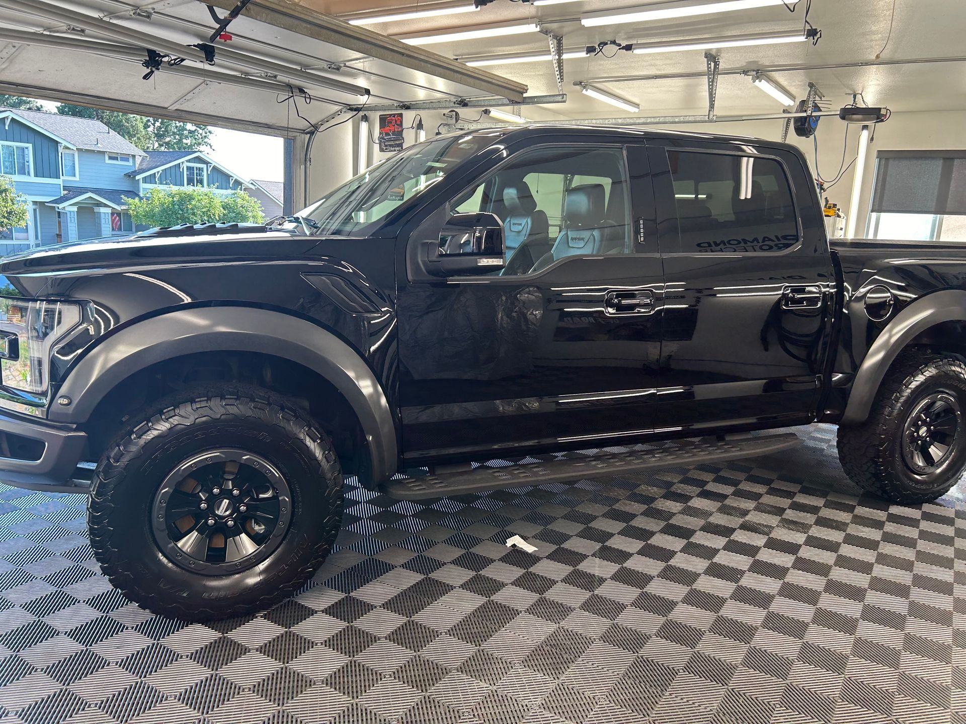 A black pickup truck is parked in a garage.