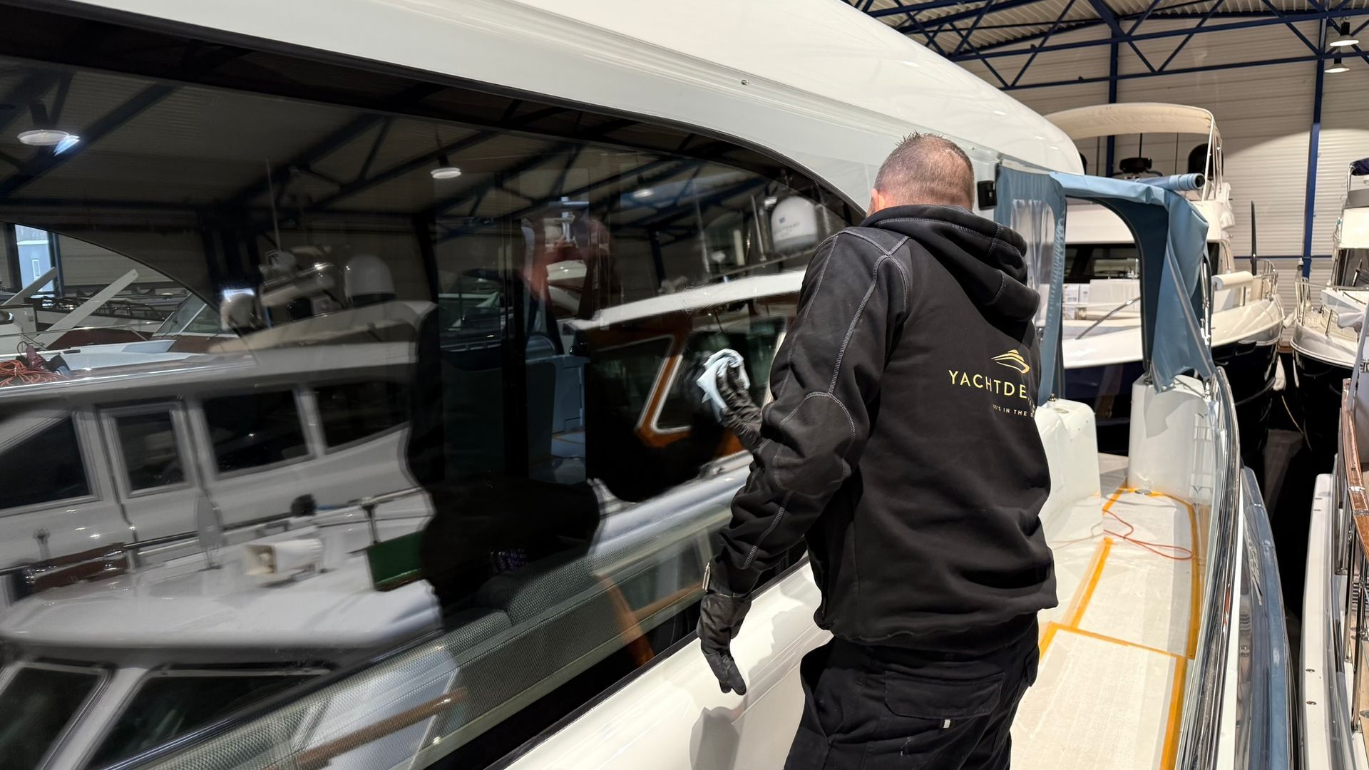 Een man werkt aan een boot in een pakhuis.