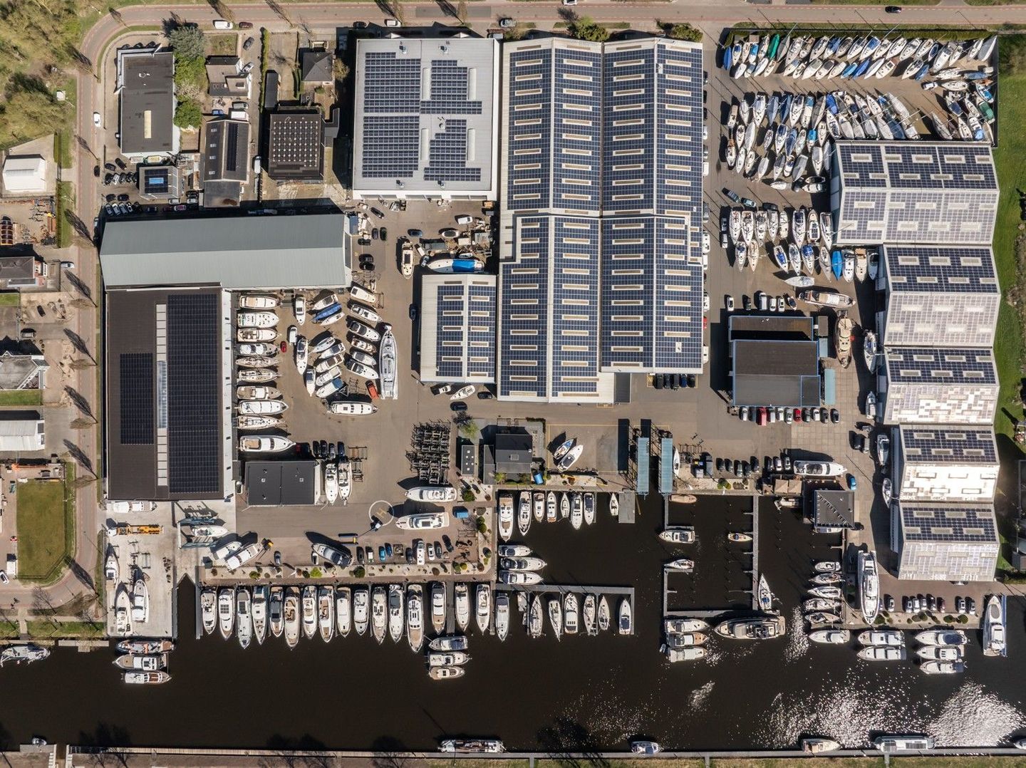 Een luchtfoto van Jachtcenter Elburg, de locatie van Yachtdetailers Elburg , u ziet een jachthaven met boten en de halen.