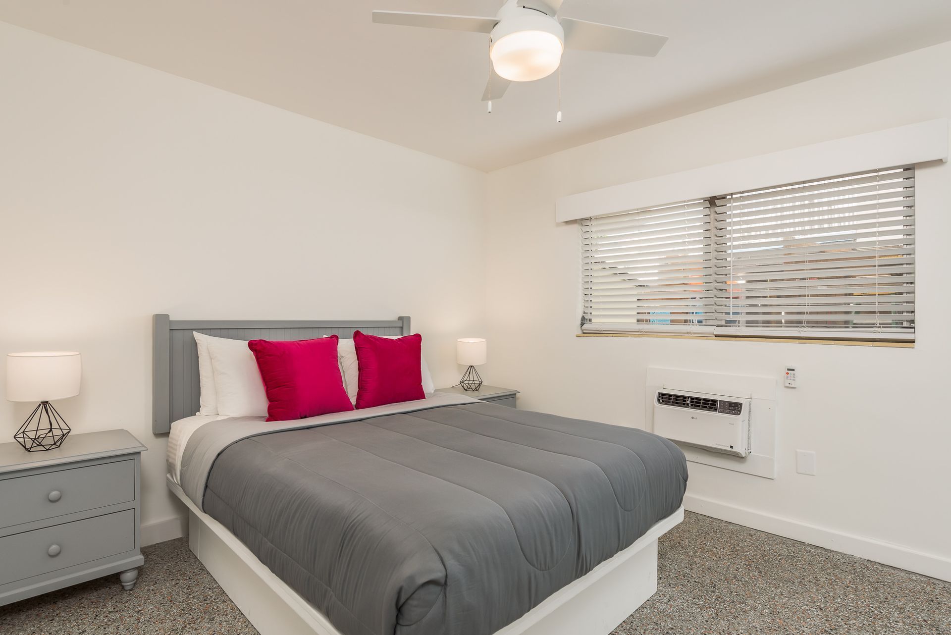 A bedroom with a king size bed and a ceiling fan