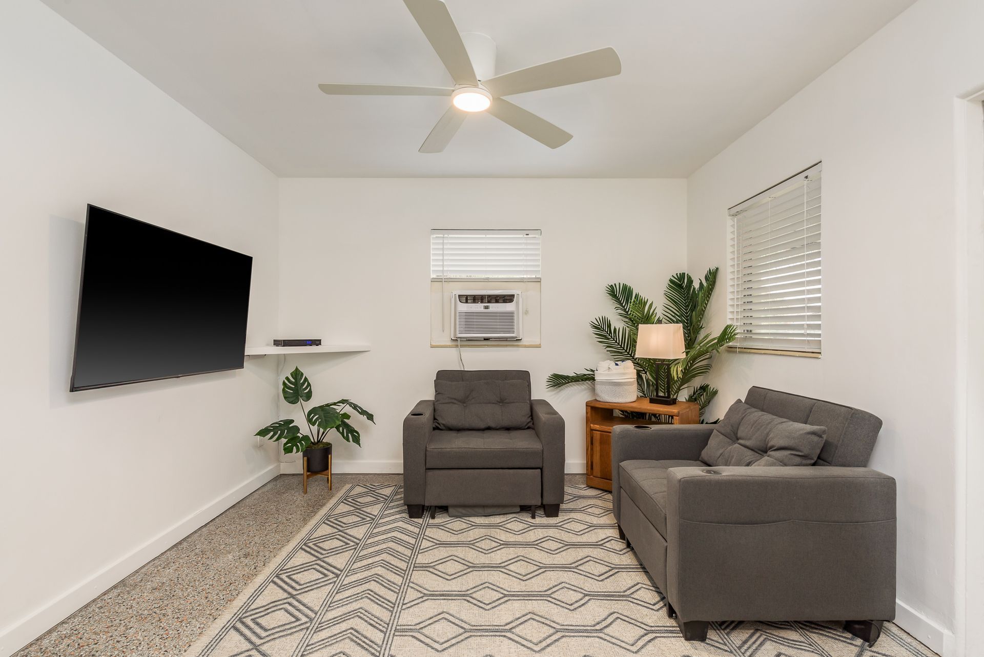 A living room with a couch a chair and a flat screen tv