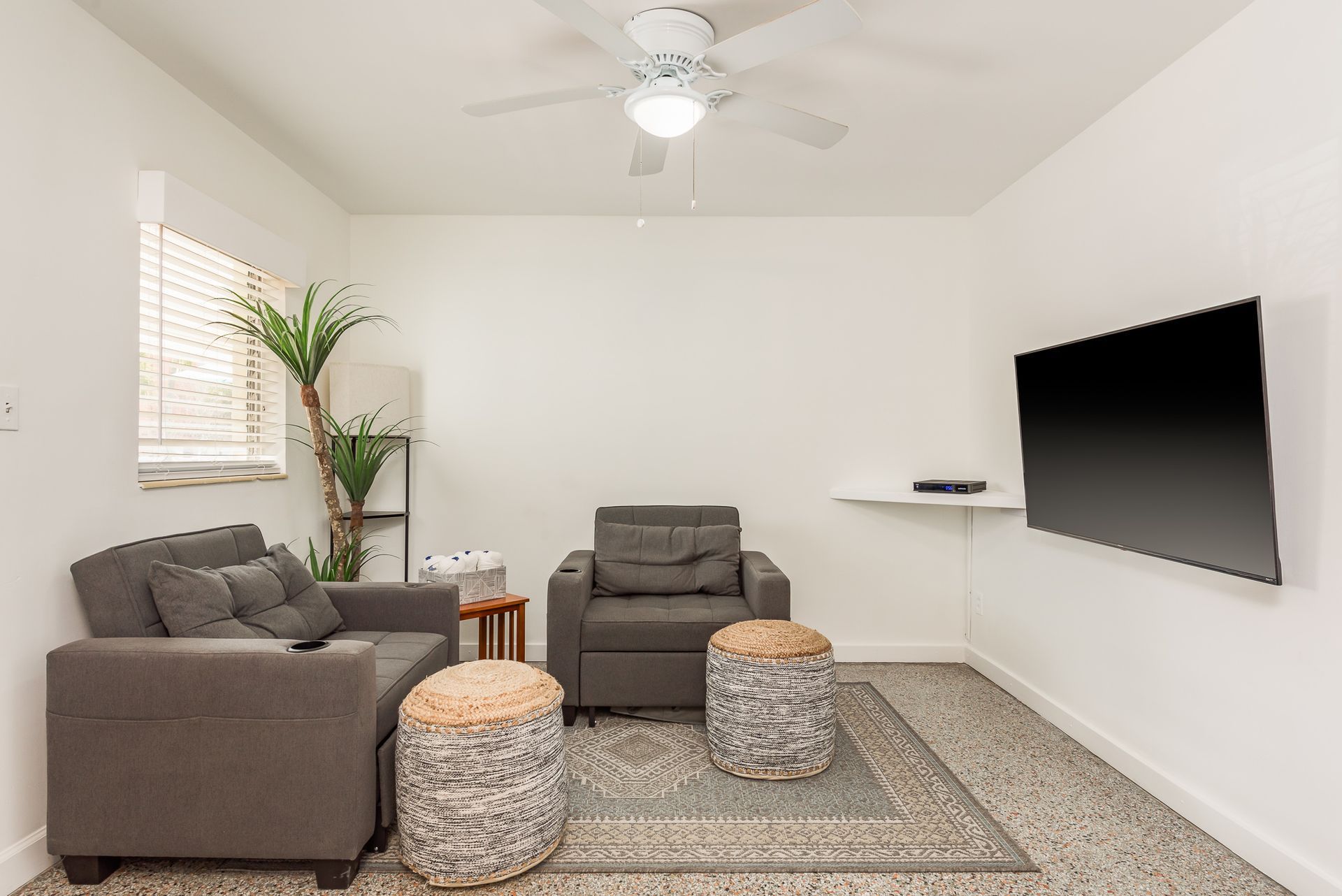 A living room with two chairs and a flat screen tv
