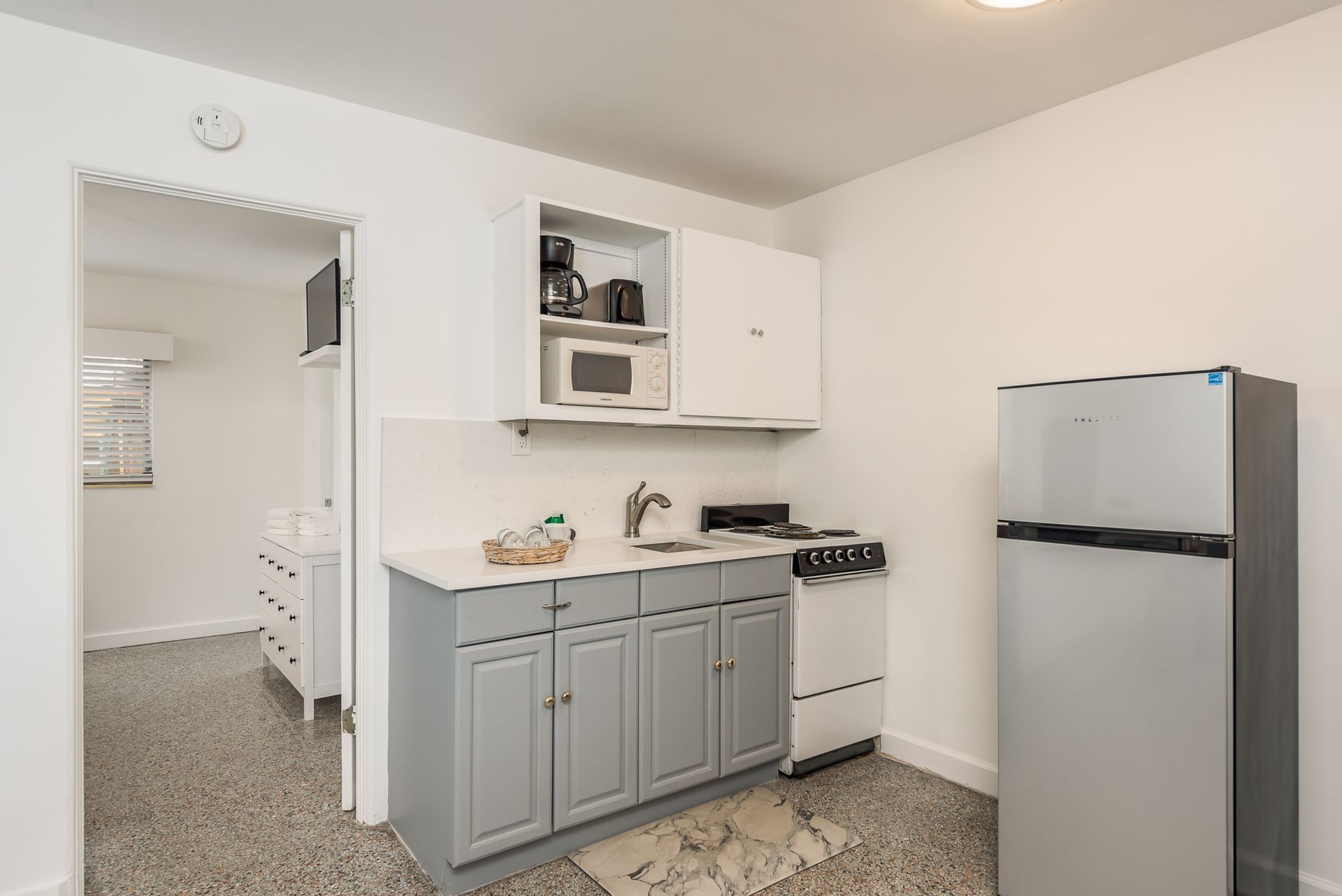 A kitchen with a refrigerator , stove , sink and microwave.