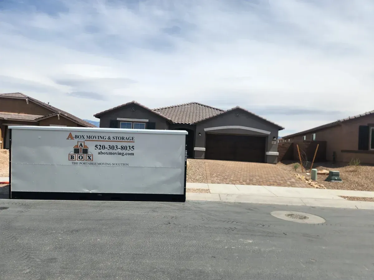 New home construction site with a white dumpster in front of a partially built house and neighboring homes