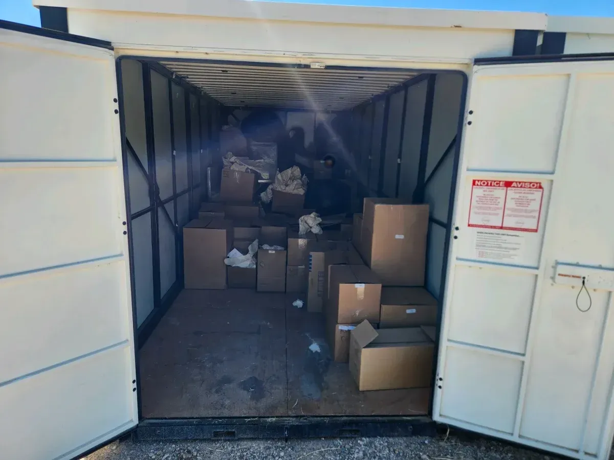Open shipping container packed with cardboard boxes and parcels