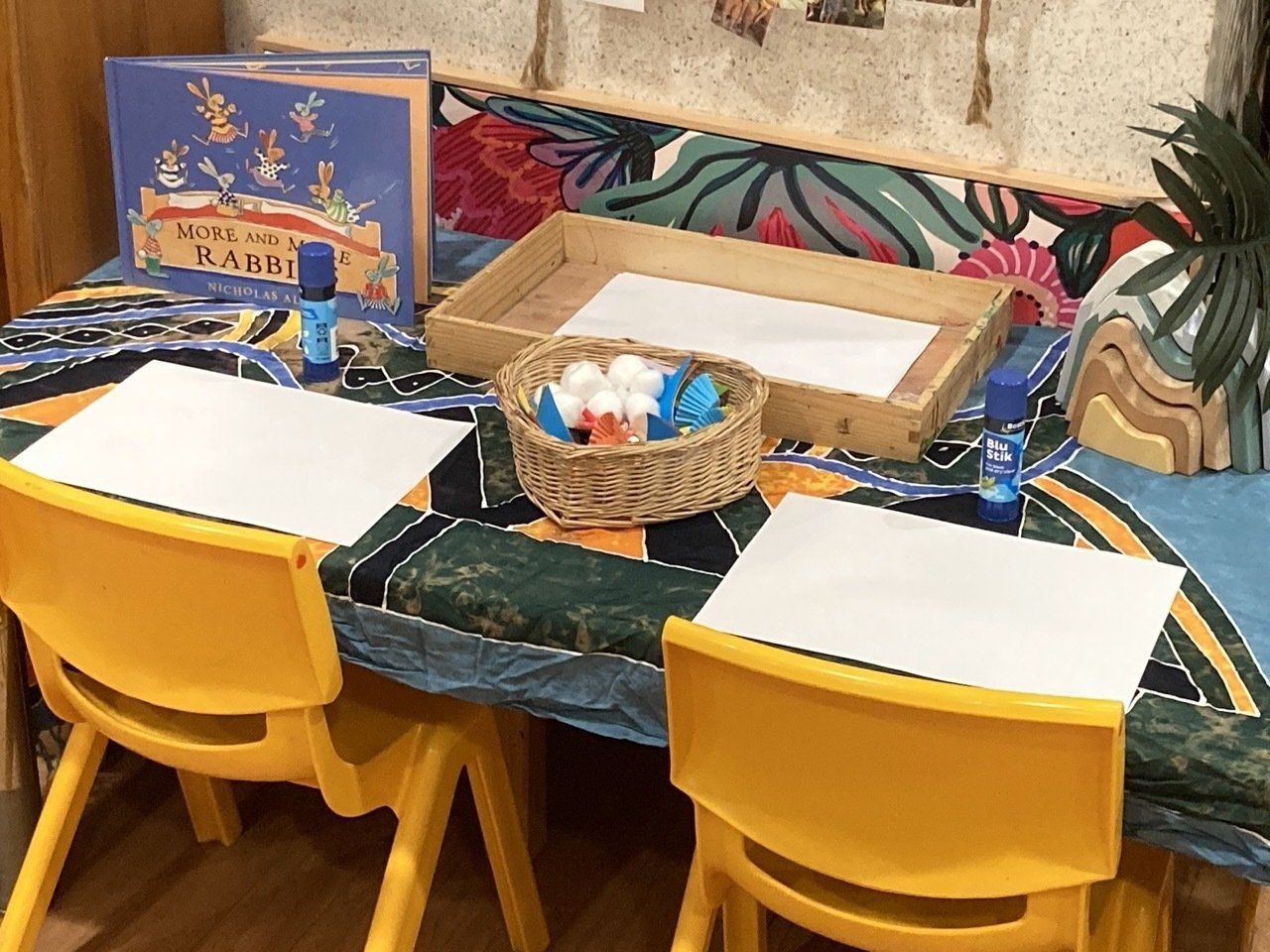A Table With Two Yellow Chairs And A Basket Of Glue On It — Juniors At Wamberal in Wamberal, NSW