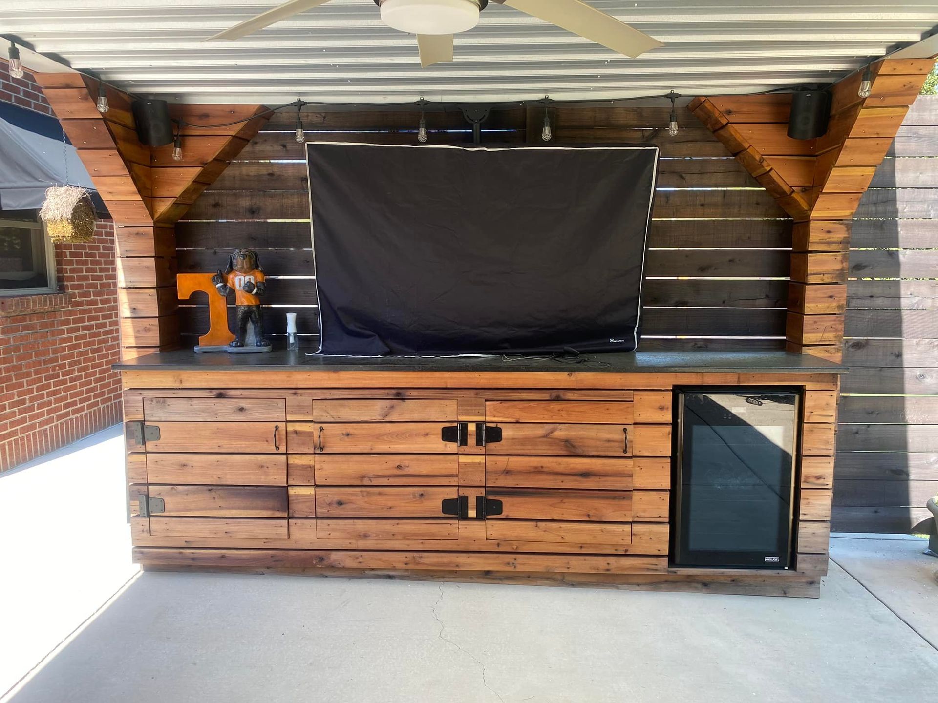 A wooden shed with a black screen on the wall