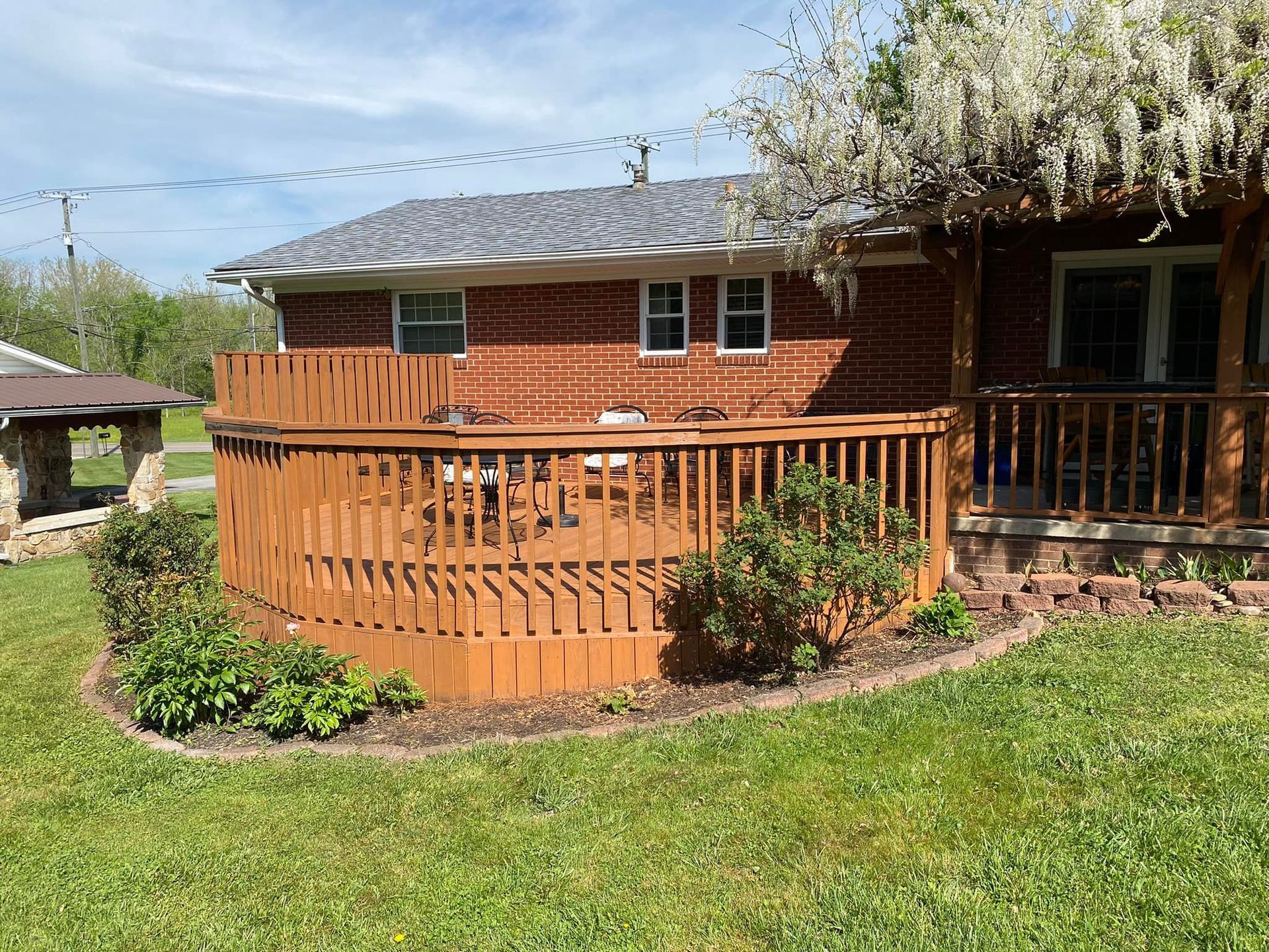 A brick house with a wooden deck in front of it.