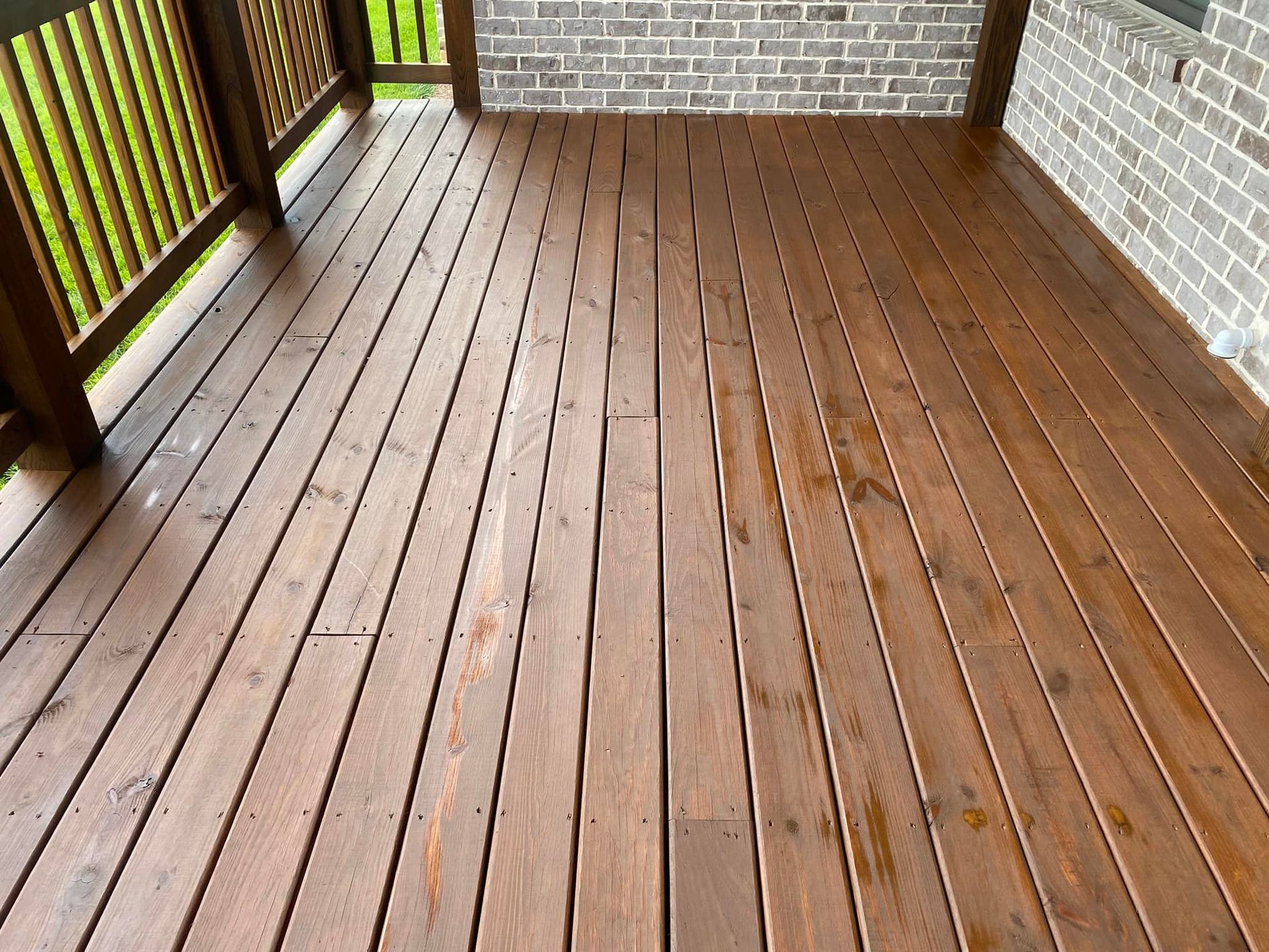 A wooden deck with a brick wall in the background.