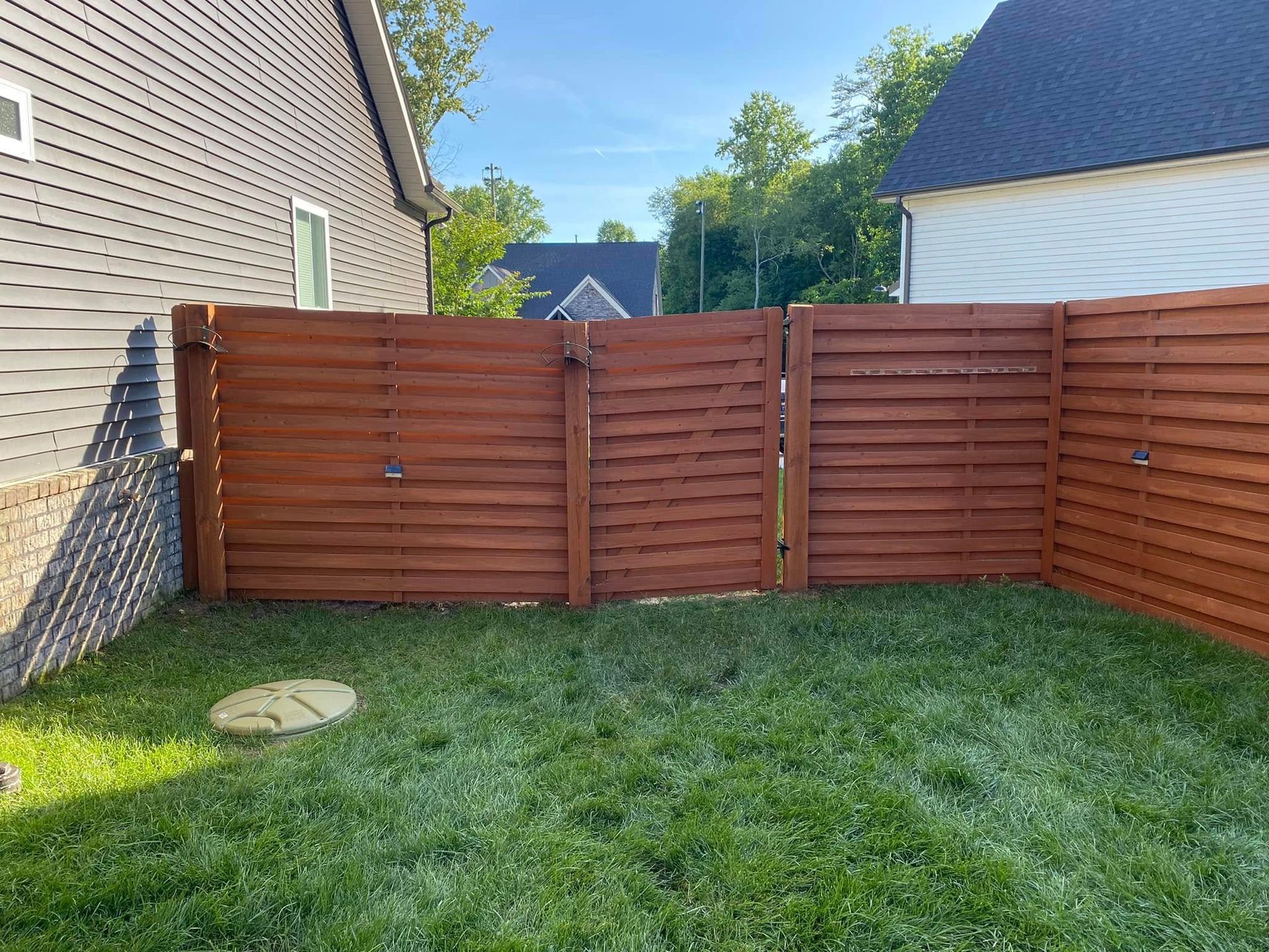 There is a wooden fence in the backyard of a house.