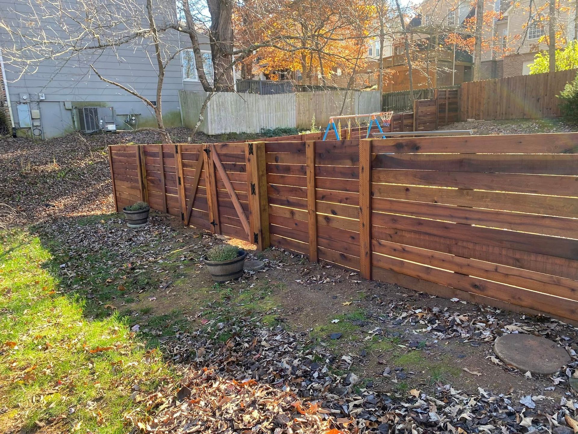 A wooden fence with a gate in the backyard of a house.