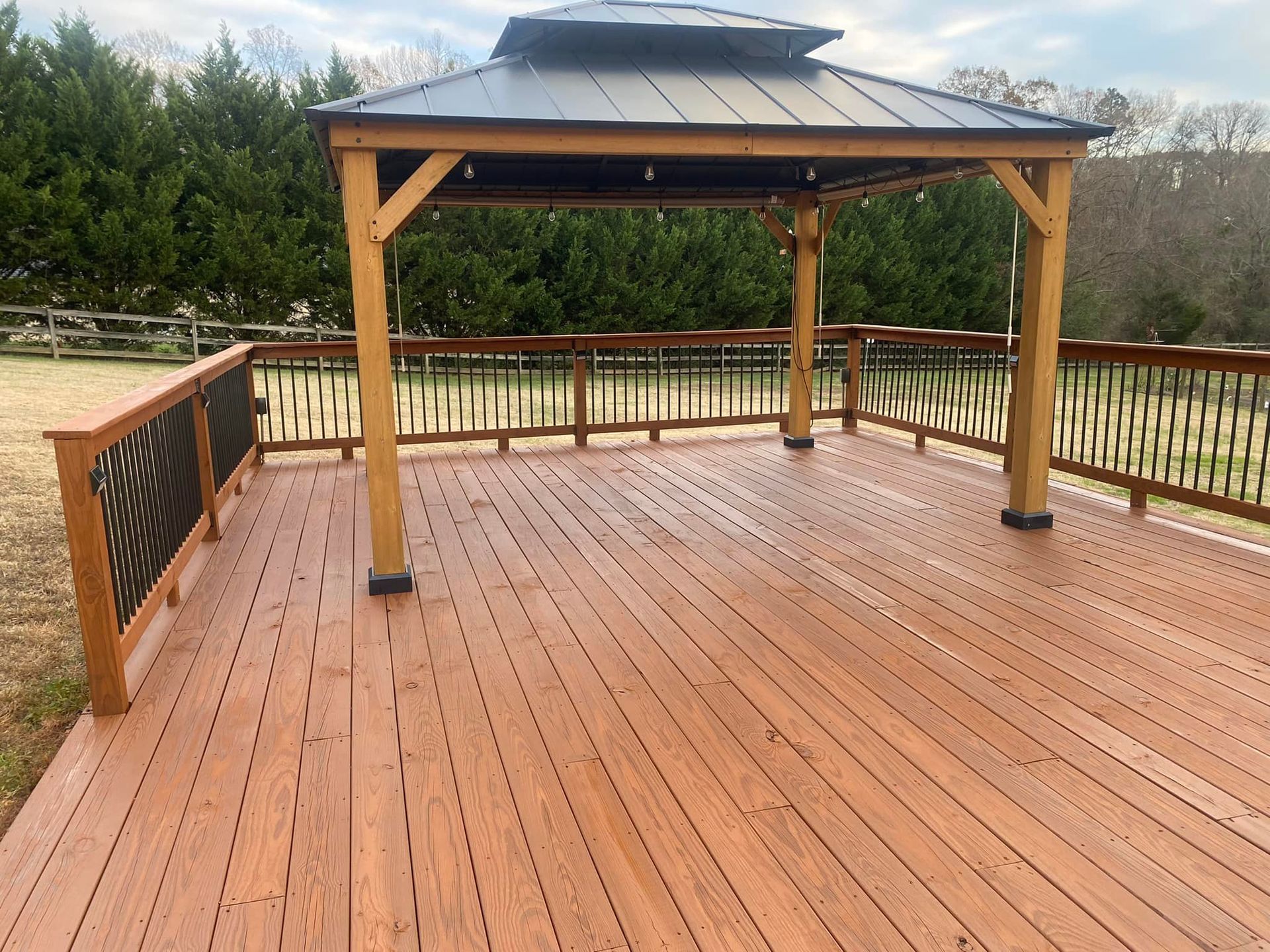 A wooden deck with a gazebo on top of it.