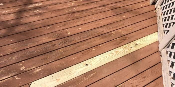 A close up of a wooden deck with a yellow line on it.