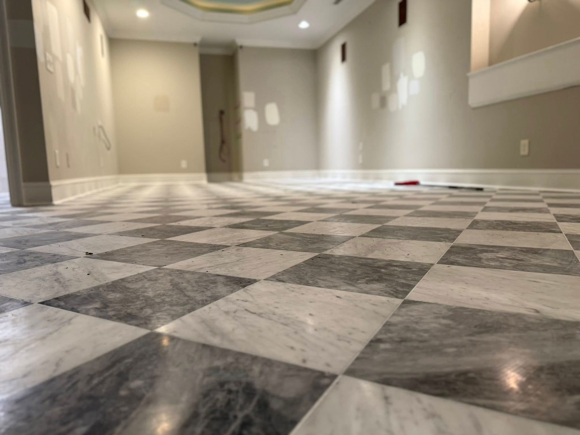 Checkerboard marble floor in a room with light gray walls and white trim.