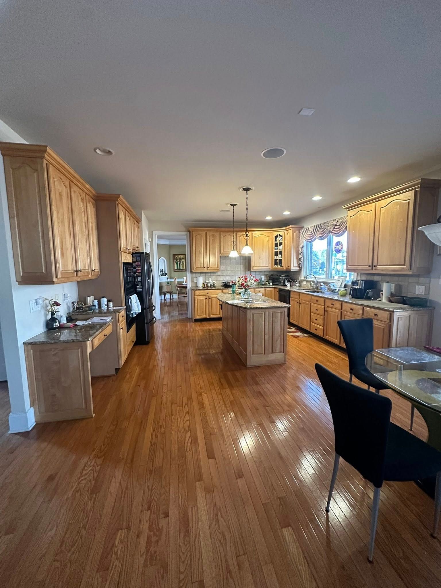Spacious kitchen with wood cabinets, island, and hardwood floors.