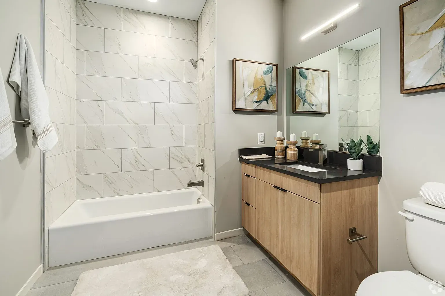 Photo of a bathroom with plenty of open walking space and a bathtub/shower combo