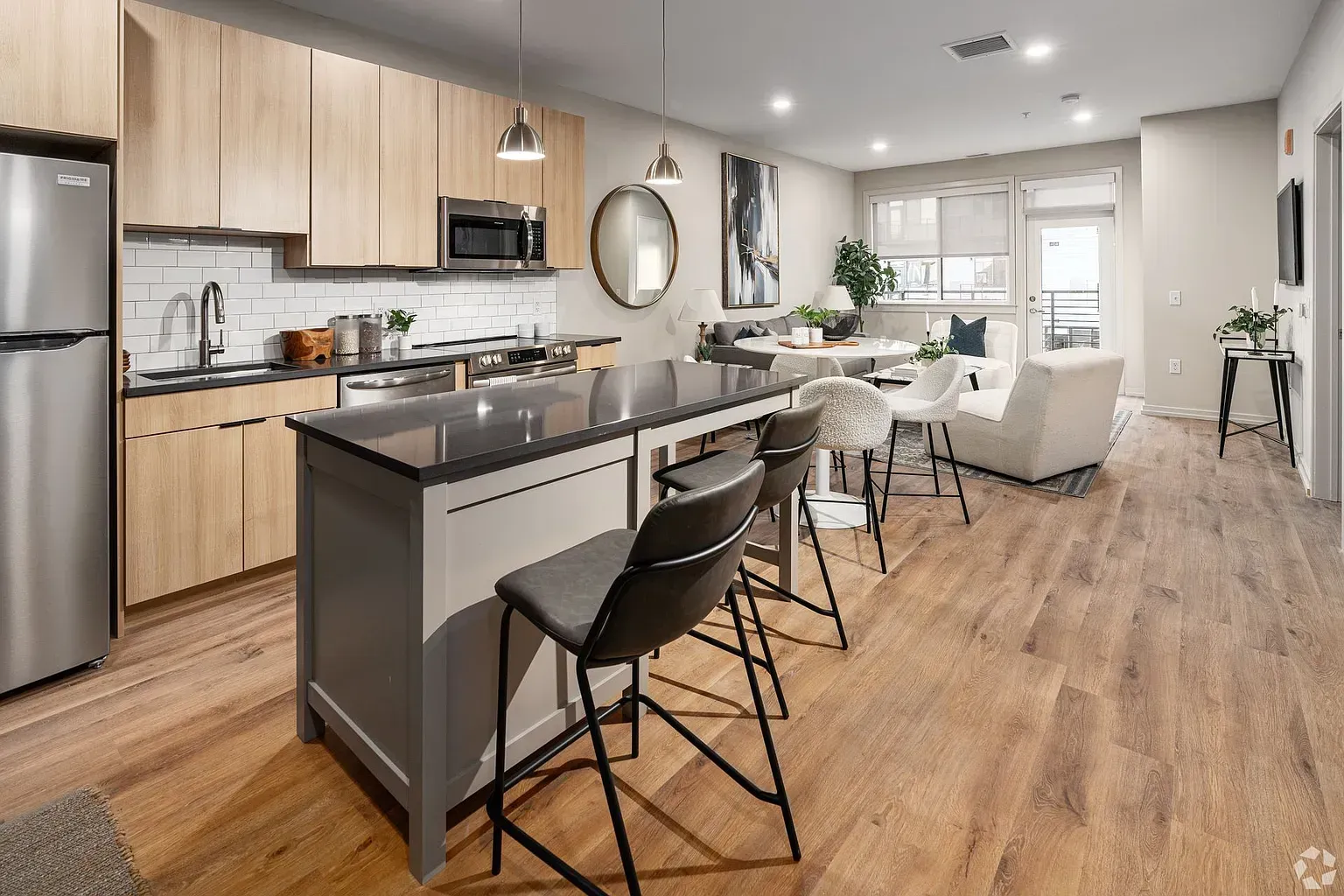 Photo of a kitchen with an island in the foreground and a living room in the background