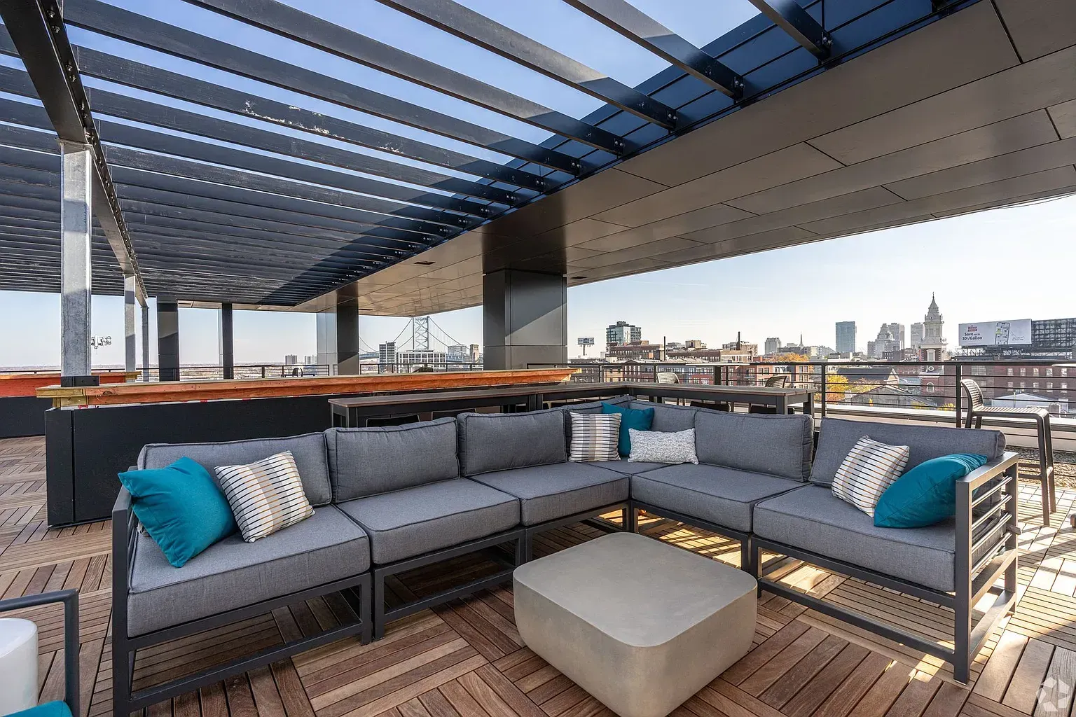 Photo of a lounge area featuring a couch and ottoman on the rooftop deck