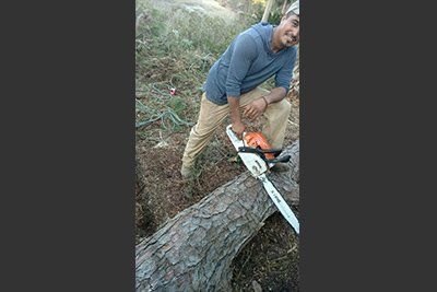 Stump Grinding — Man Holding a Chain Saw in Savannah, GA