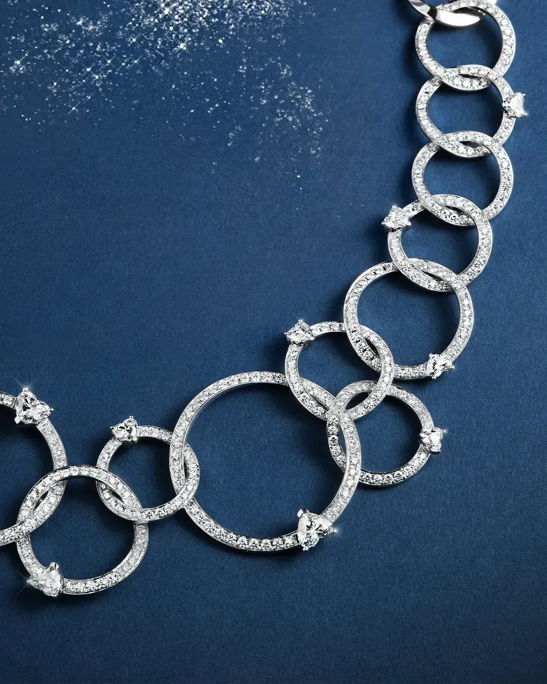 Collana con maglie di diamanti su sfondo blu scuro.