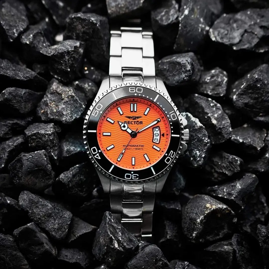 Orologio da polso in argento con quadrante arancione e lunetta nera su fondo scuro.