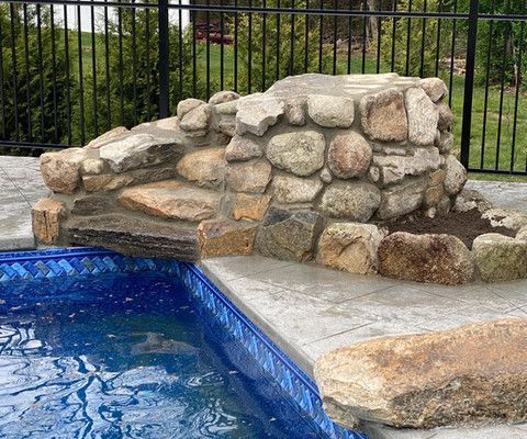 There is a waterfall in the middle of the pool.