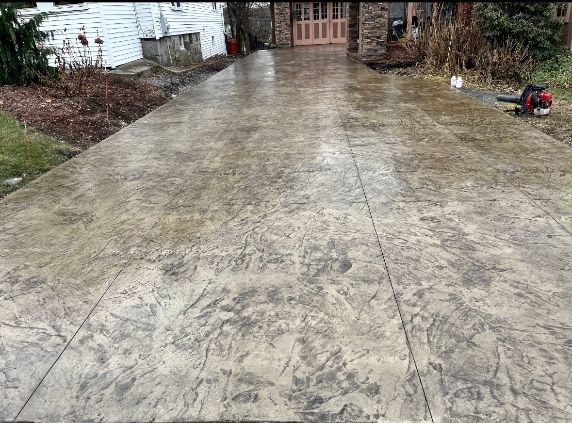 Bricked concrete driveway with a textured pattern for added visual appeal and traction.