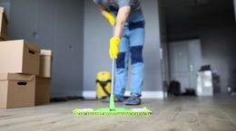 A man is cleaning the floor with a mop.