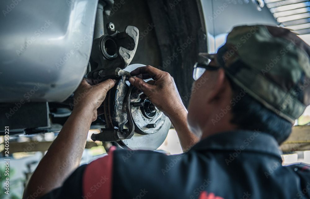 A man is working on a car in a garage.