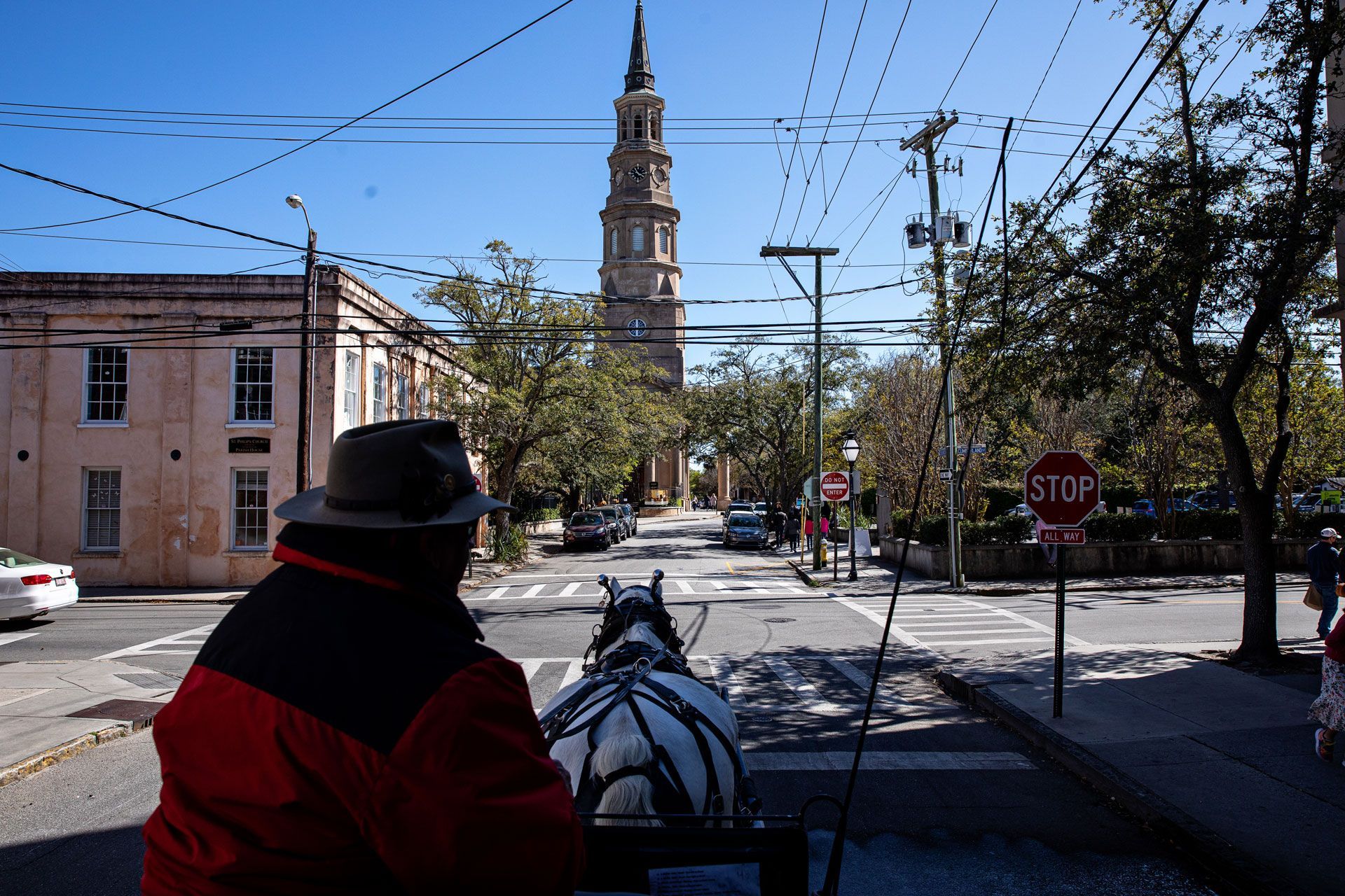 A horse drawn carriage with a stop sign in the background