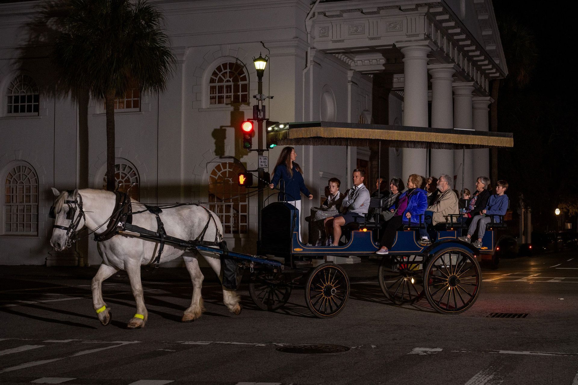 A group of people are riding in a horse drawn carriage.