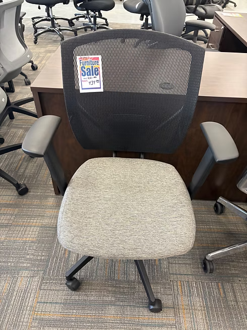 Office chair with mesh back, gray seat, and sale tag.