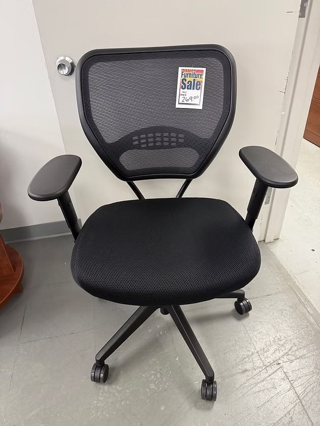 Black office chair with mesh back and armrests, on wheels.