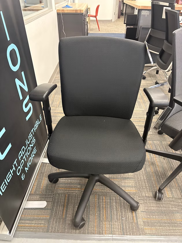 Black office chair with padded seat and back, adjustable arms, and five-star base.