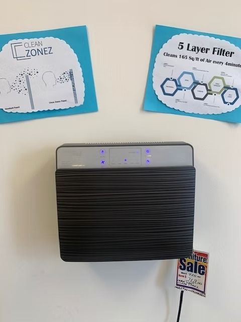 Air purifier on wall with two informational signs.