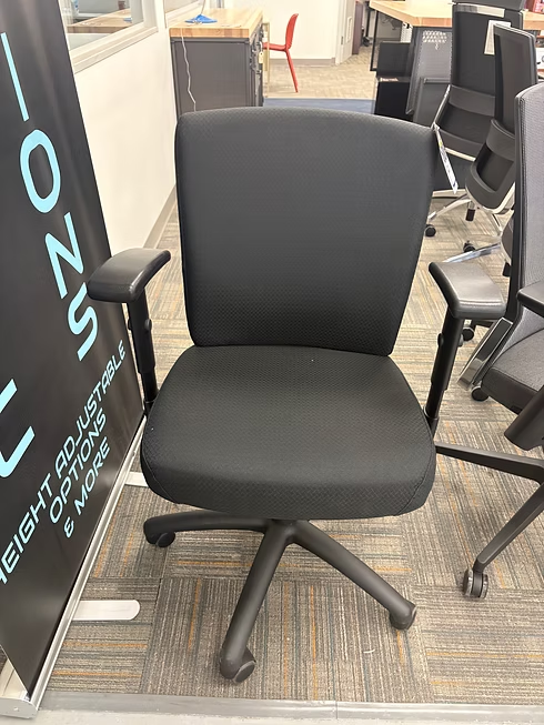 Black office chair with armrests, on wheels, in an office setting.