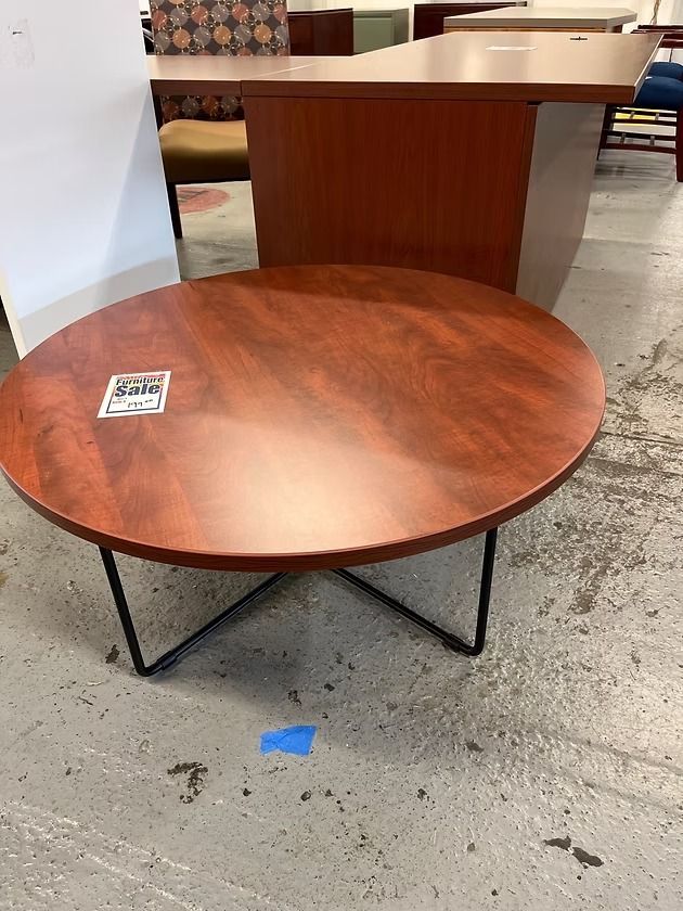 Round, brown table with black metal legs, with a
