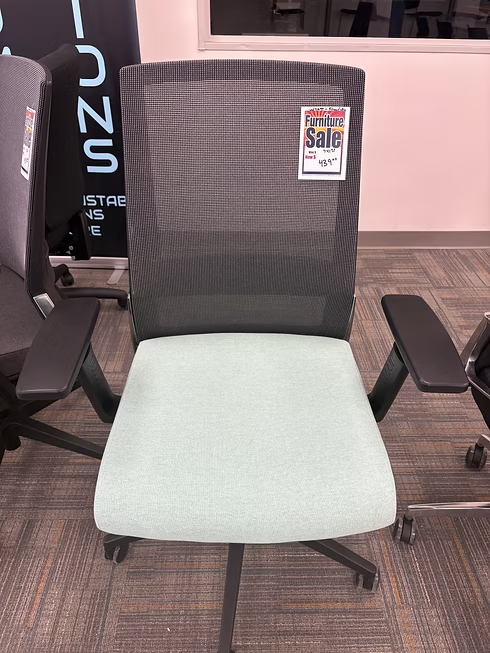 Office chair with a gray mesh back and light green seat; a 