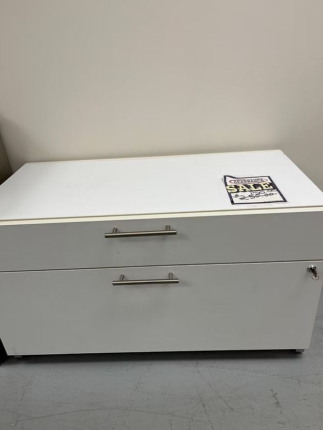 White storage cabinet with two drawers and silver handles.