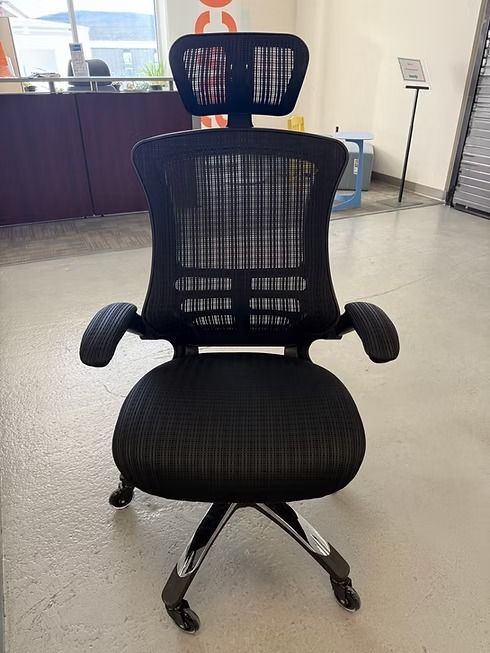 Black ergonomic office chair with headrest, mesh back and seat, chrome base, and armrests.
