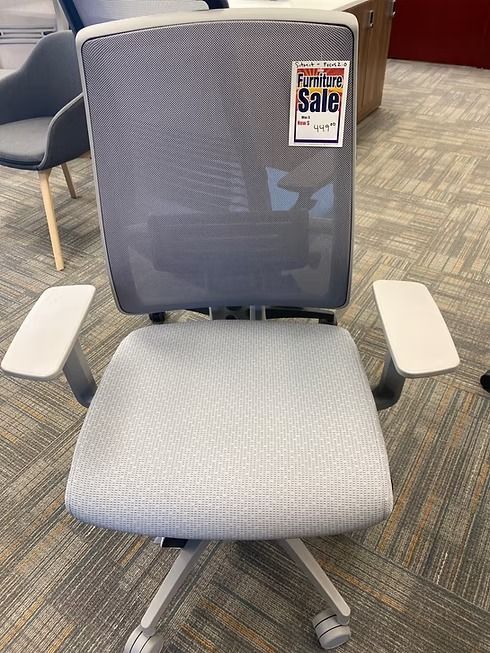 Gray and white office chair on a patterned carpet, with a 
