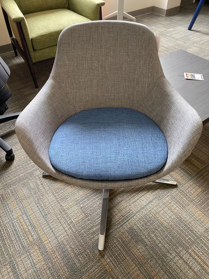 Gray and blue swivel armchair on patterned carpet.