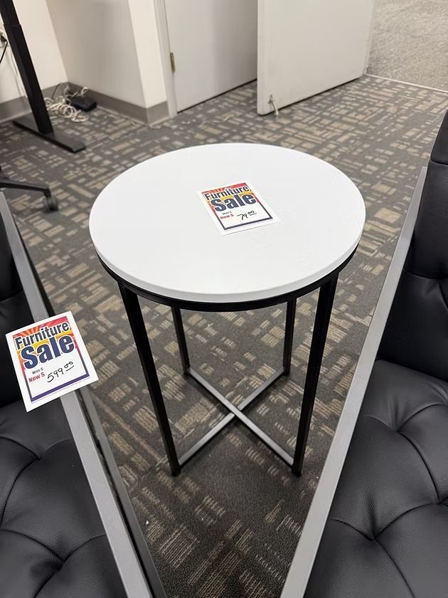 White top side table with black legs, sale tag.