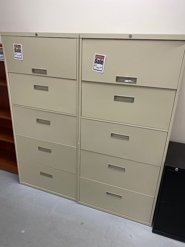 Two tan metal filing cabinets with four drawers each.